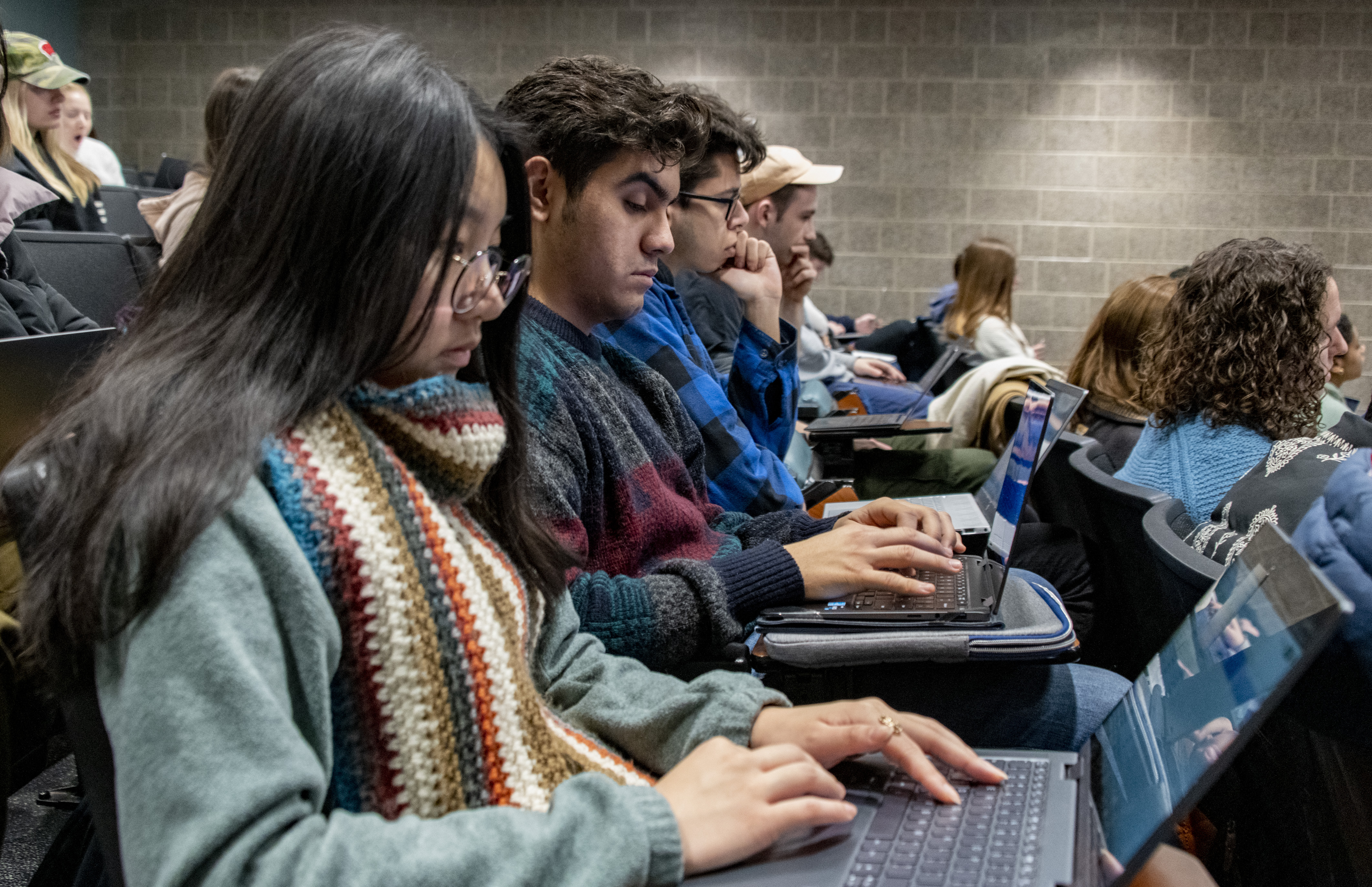 Students taking notes on their laptops in a course